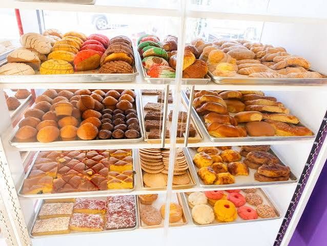 Pastry case filled with colorful conchas, breads, and cookies.